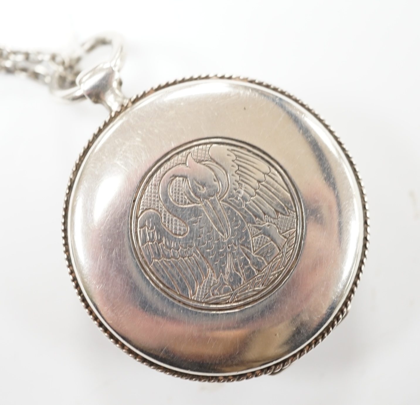 An Edwardian silver circular pyx by Carl Krall, the cover engraved with a bird with new born chicks, London, 1909, diameter 43mm, together with a white metal chain. Good condition